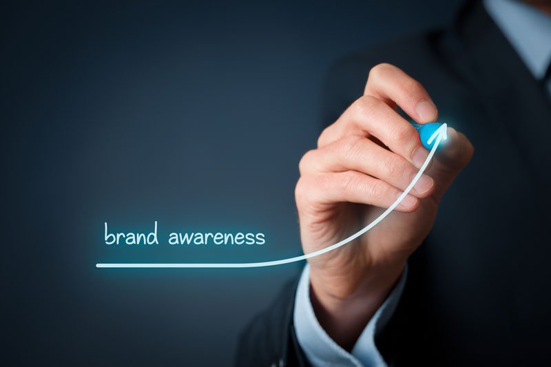 Businessman writing brand awareness with a line showing an increase | Mage H.D. | Mage H.D.